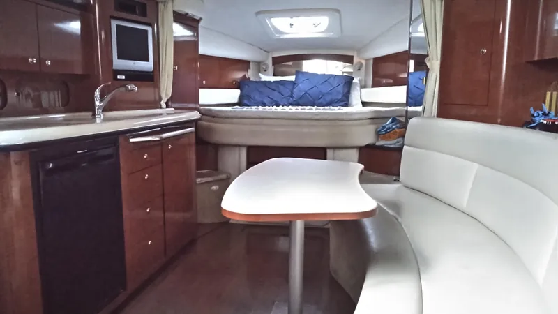 Slide: The Image of 2004 Sea Ray 340 Sundancer interior with kitchen, dining area, and bed. - 25