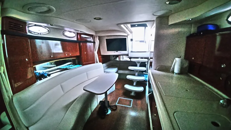 Slide: The Image of Interior of 2004 Sea Ray 340 Sundancer yacht with seating, table, and kitchenette. - 27