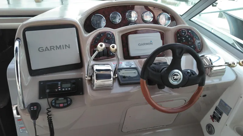 Slide: The Image of 2004 Sea Ray 340 Sundancer helm with Garmin navigation system and wood-trimmed steering wheel. - 29