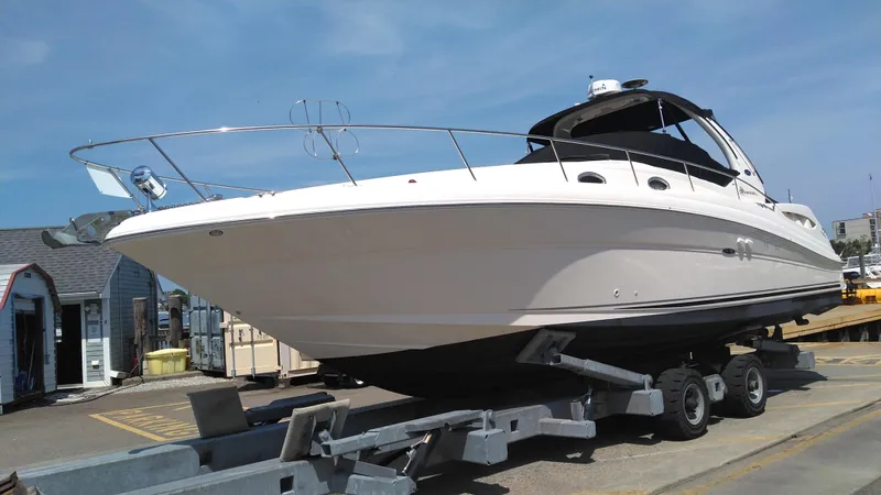 Slide: The Image of 2004 Sea Ray 340 Sundancer boat on a trailer at a marina. - 6