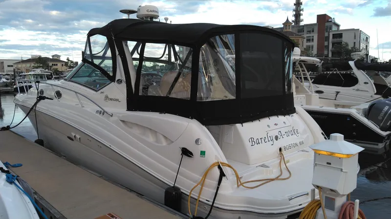 Slide: The Image of 2004 Sea Ray 340 Sundancer docked at a marina with black canvas cover. - 8