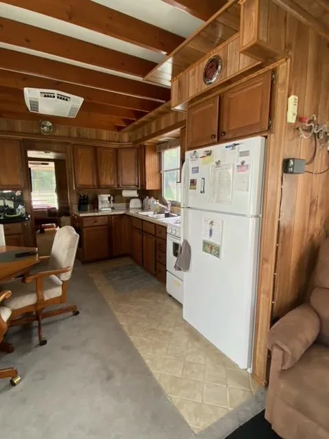 Slide: The Image of 1984 Sumerset Houseboat 14 x 60 kitchen with wooden cabinets and white appliances. - 9