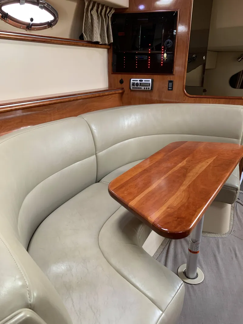 Slide: The Image of 2006 Cruisers 320 Express yacht interior with leather seating and wooden table. - 11