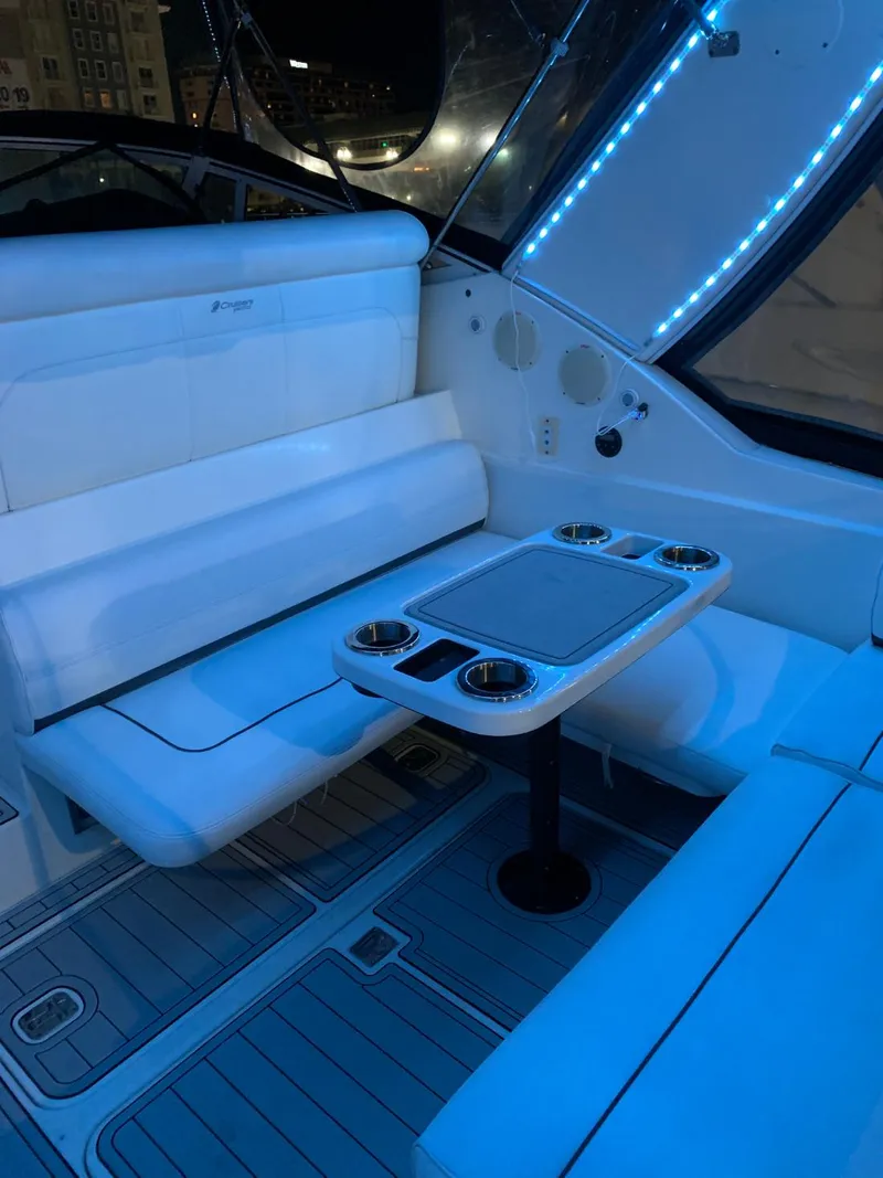 Slide: The Image of 2006 Cruisers 320 Express boat interior with seating and table, blue LED lighting. - 23