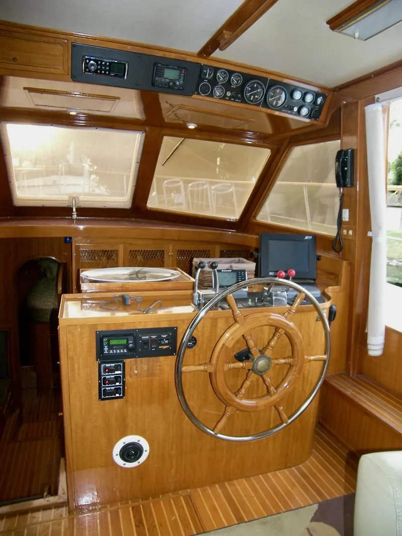 Slide: The Image of 1984 Symbol 51 yacht helm with wooden steering wheel and navigation instruments. - 17