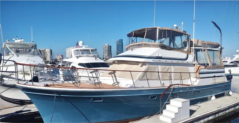 Slide: The Image of 1984 Symbol 51 yacht docked at marina, clear blue sky, city skyline in background. - 2