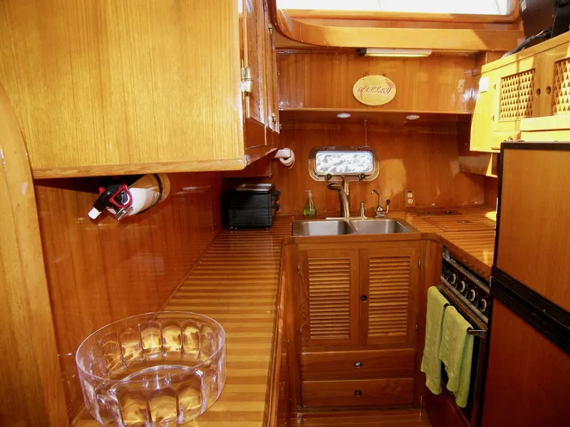 Slide: The Image of Luxurious wooden yacht kitchen interior with sink, stove, and ample storage, Symbol 51, 1984 model. - 23