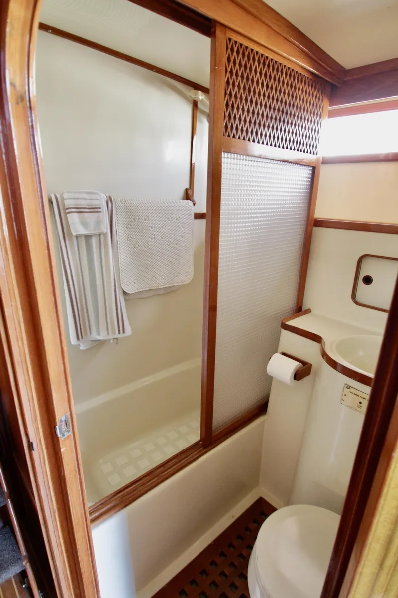 Slide: The Image of 1984 Symbol 51 yacht bathroom with wooden accents, shower, and toilet. - 36