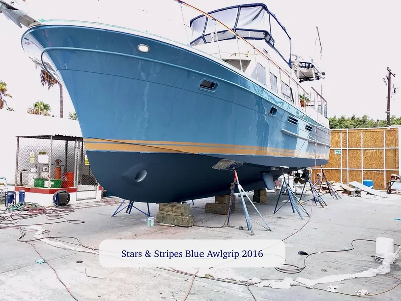 Slide: The Image of Blue boat on stands, undergoing maintenance, labeled "Stars & Stripes Blue Awlgrip 2016." - 4