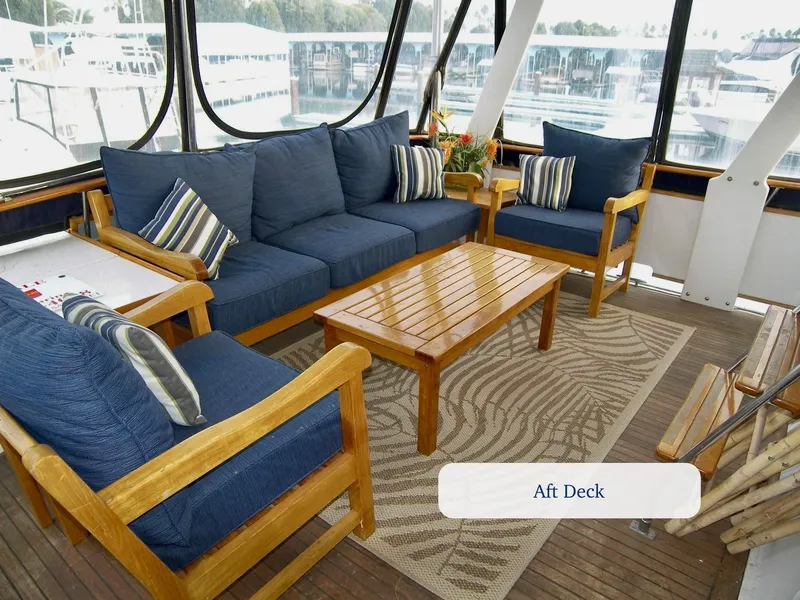 Slide: The Image of Aft deck of 1984 Symbol 51 yacht with blue cushioned seating and wooden table. - 7