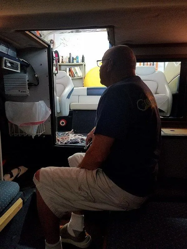 Slide: The Image of Man sitting inside a 1992 Crownline 210 CCR boat cabin. - 6