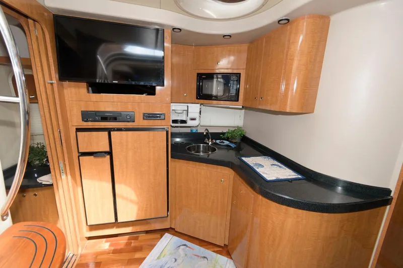 Slide: The Image of 2002 Regal Commodore 3860 yacht kitchen with modern appliances and wooden cabinetry. - 13