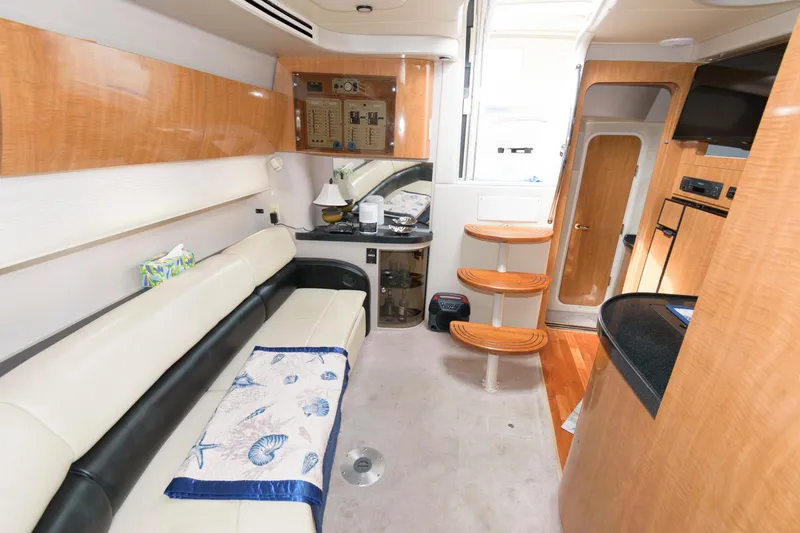 Slide: The Image of Interior of 2002 Regal Commodore 3860 yacht with beige seating and wooden cabinetry. - 14