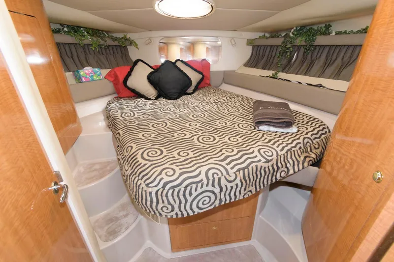 Slide: The Image of 2002 Regal Commodore 3860 boat cabin with bed, pillows, and decorative plants. - 15