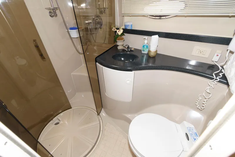 Slide: The Image of 2002 Regal Commodore 3860 yacht bathroom with shower, sink, and toilet. - 16