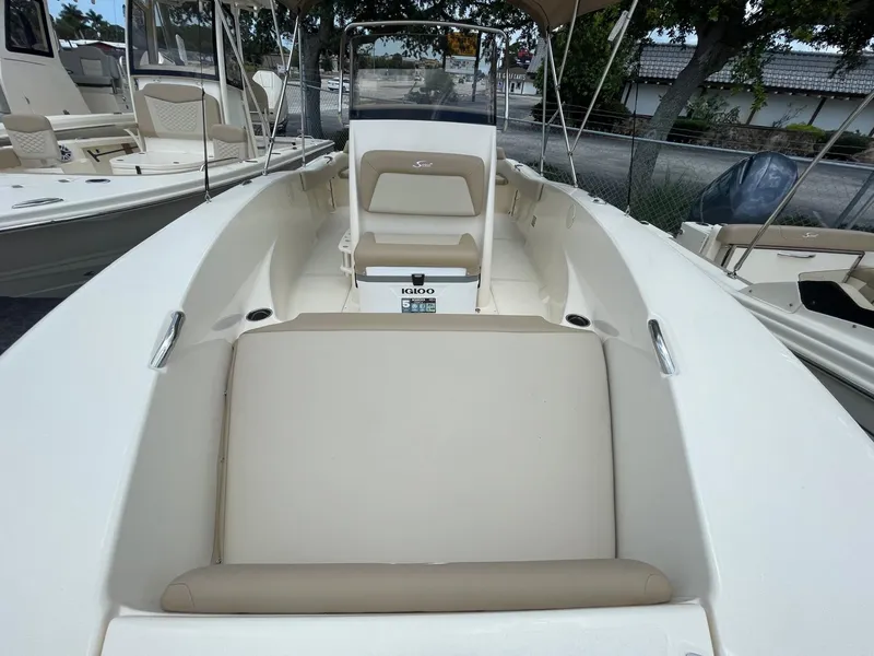 Slide: The Image of 2024 Scout 195 Sportfish boat interior with beige seating and steering console. - 10
