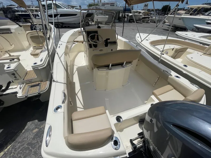 Slide: The Image of 2024 Scout 195 Sportfish boat with beige seating and outboard motor. - 3