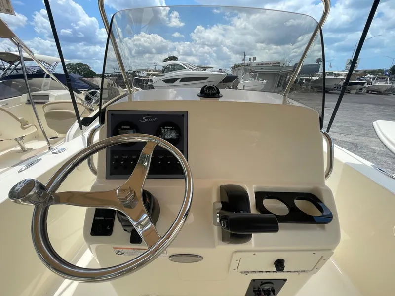 Slide: The Image of 2024 Scout 195 Sportfish boat dashboard with steering wheel and controls. - 5