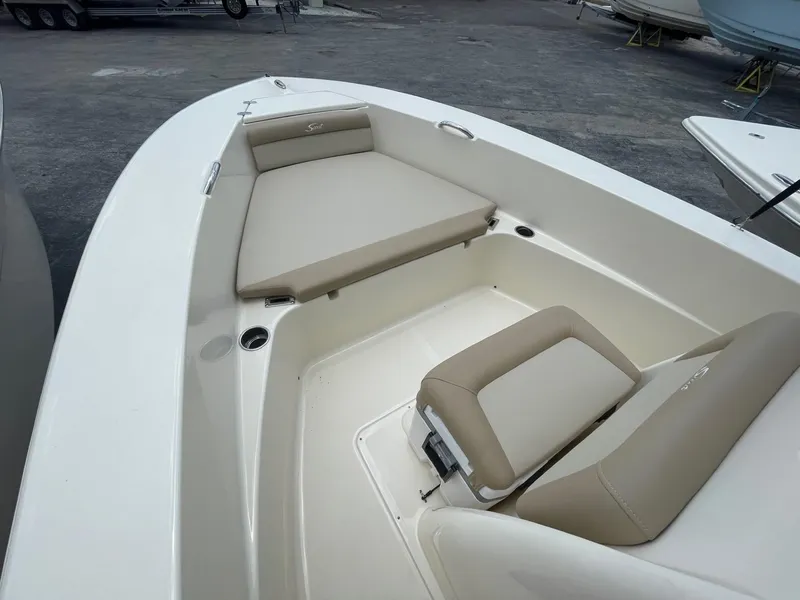 Slide: The Image of 2024 Scout 195 Sportfish boat interior with beige seating and storage compartments. - 9