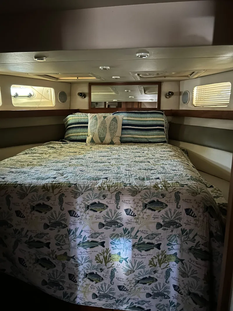 Slide: The Image of Cozy bedroom in 1994 Bayliner 4788 yacht with nautical-themed bedding. - 11