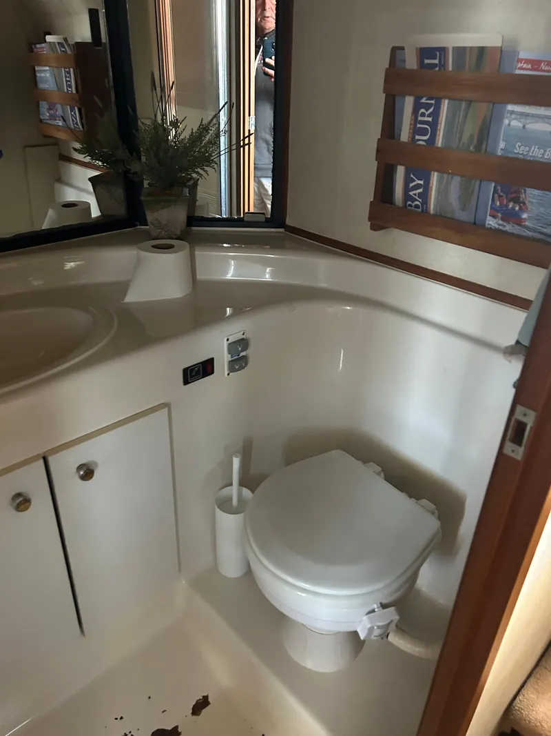 Slide: The Image of 1994 Bayliner 4788 yacht bathroom with toilet, sink, and magazine rack. - 13