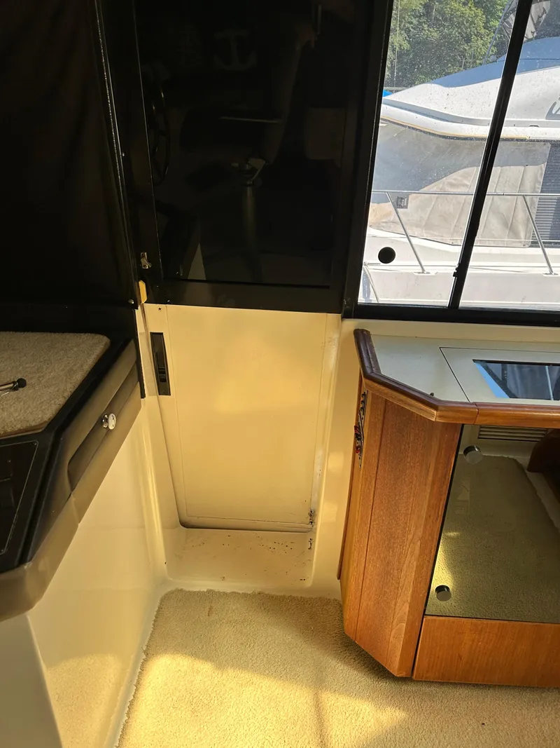 Slide: The Image of Interior of a 1994 Bayliner 4788 yacht with carpeted floor and wooden cabinetry. - 19