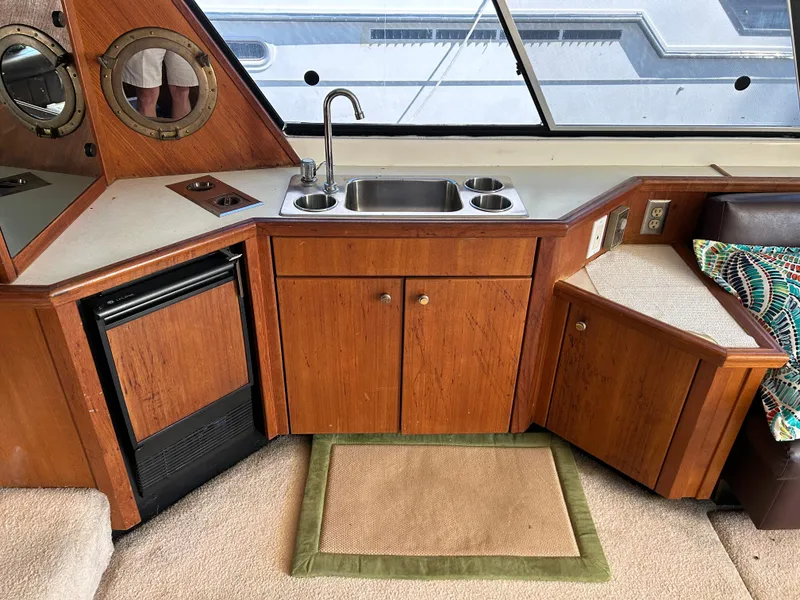 Slide: The Image of 1994 Bayliner 4788 yacht interior kitchen with sink, stove, and mini-fridge. - 24
