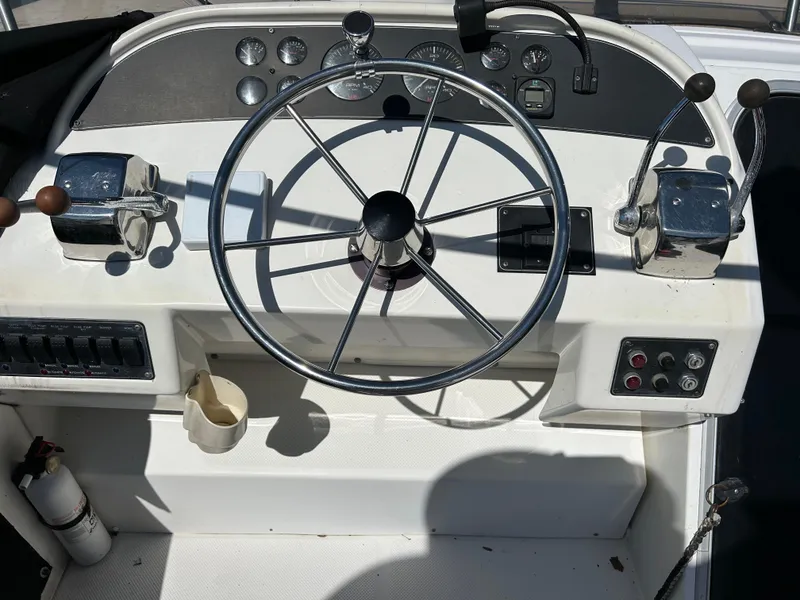 Slide: The Image of 1994 Bayliner 4788 boat helm with steering wheel and control panel. - 4