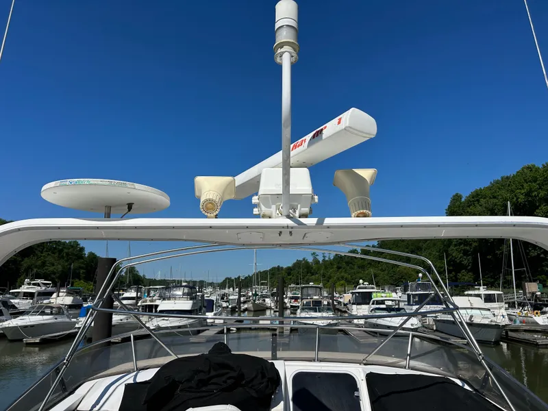 Slide: The Image of 1994 Bayliner 4788 yacht docked at a marina with clear blue skies. - 5
