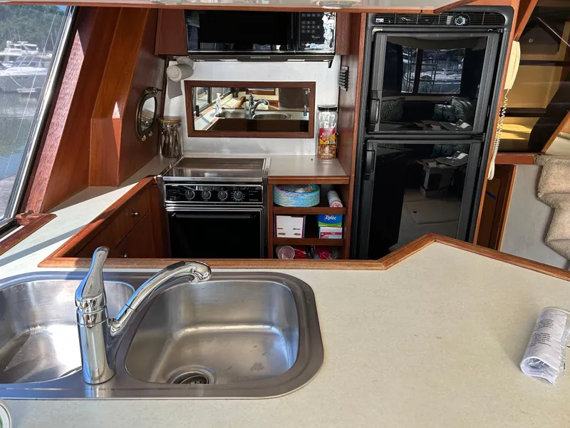 Slide: The Image of 1994 Bayliner 4788 yacht kitchen with sink, stove, and refrigerator. - 9