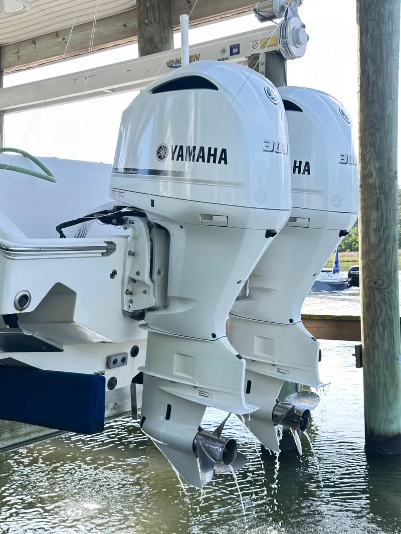 Slide: The Image of Twin Yamaha outboard motors on a 2019 Jupiter 30 HFS boat, docked in water. - 11