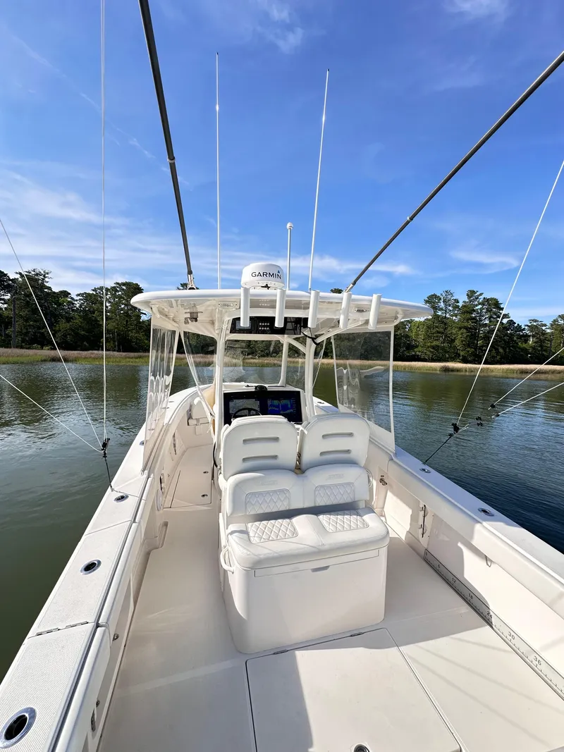 Slide: The Image of 2019 Jupiter 30 HFS boat on calm water, clear sky, and lush shoreline. - 14