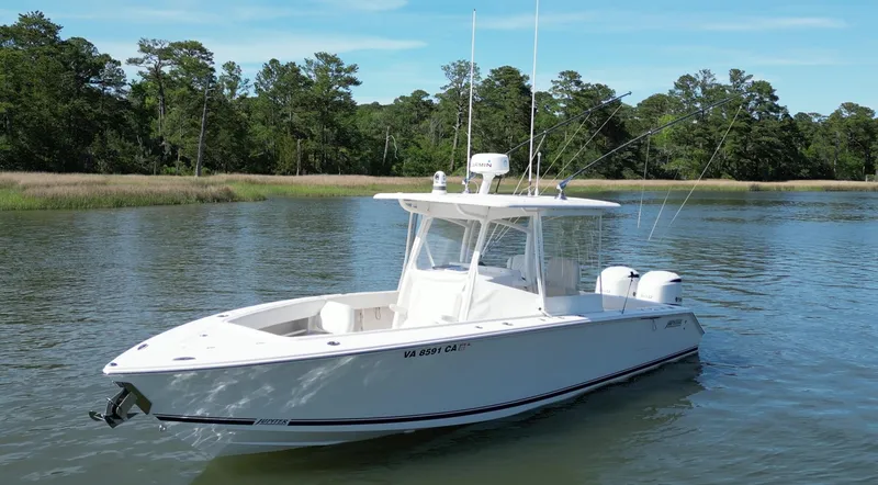 Slide: The Image of 2019 Jupiter 30 HFS boat on calm water with lush green trees. - 5