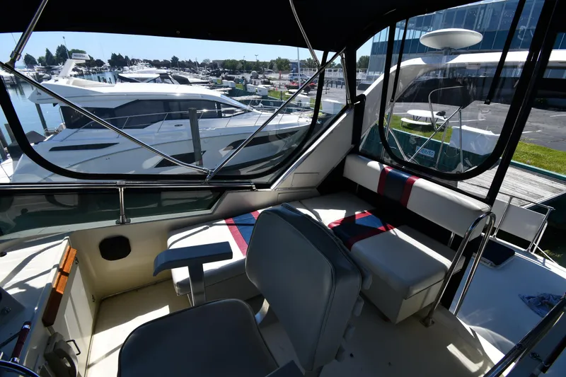 Slide: The Image of 1988 Tollycraft 34 Sundeck interior view with seating and marina background. - 25