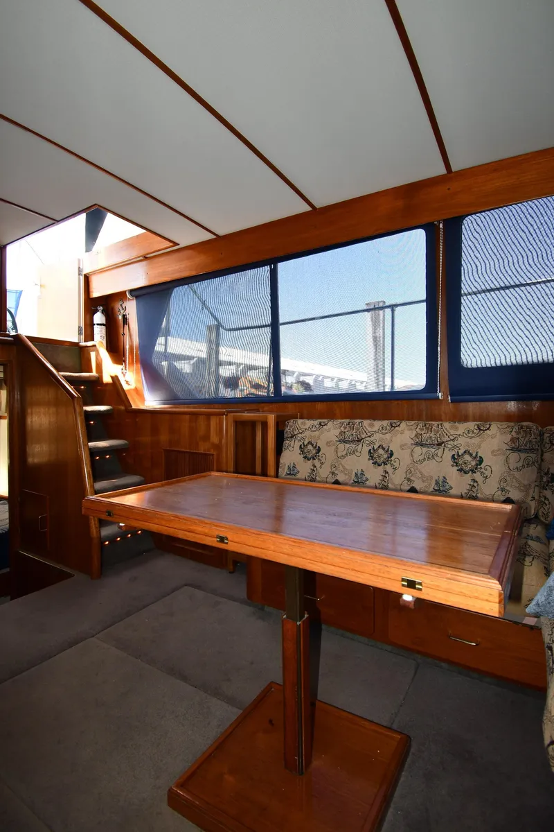Slide: The Image of Interior of 1988 Tollycraft 34 Sundeck with wooden table and cushioned seating. - 41