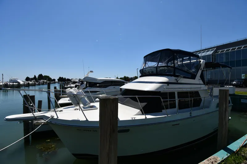The Image of 1988 Tollycraft 34 Sundeck yacht docked at a marina on a sunny day. - 0