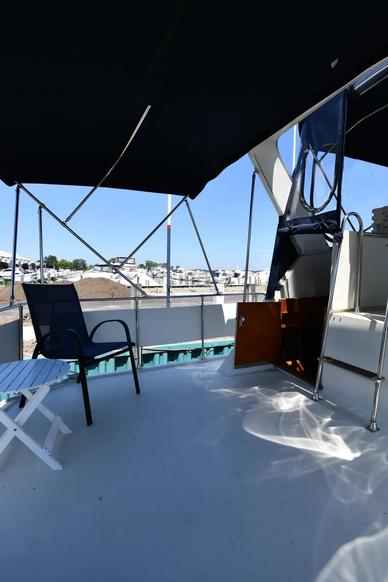 Slide: The Image of 1988 Tollycraft 34 Sundeck yacht with shaded seating area and marina view. - 10