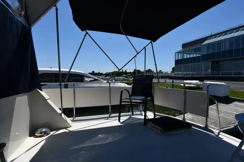 Slide: The Image of 1988 Tollycraft 34 Sundeck yacht with shaded seating area at the dock. - 11
