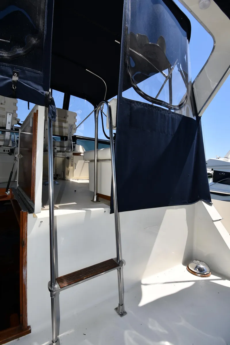 Slide: The Image of 1988 Tollycraft 34 Sundeck yacht with ladder and covered deck area. - 13