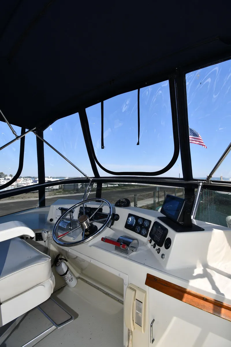 Slide: The Image of 1988 Tollycraft 34 Sundeck helm with steering wheel and navigation instruments. - 15
