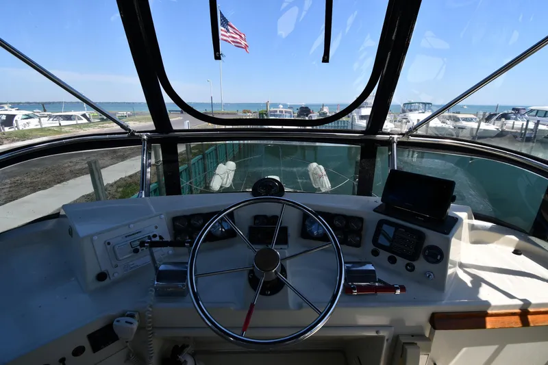 Slide: The Image of 1988 Tollycraft 34 Sundeck helm with ocean view and American flag. - 18