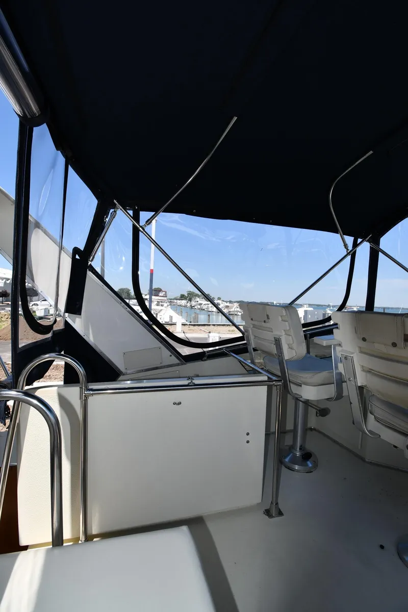Slide: The Image of 1988 Tollycraft 34 Sundeck with covered seating area and marina view. - 24
