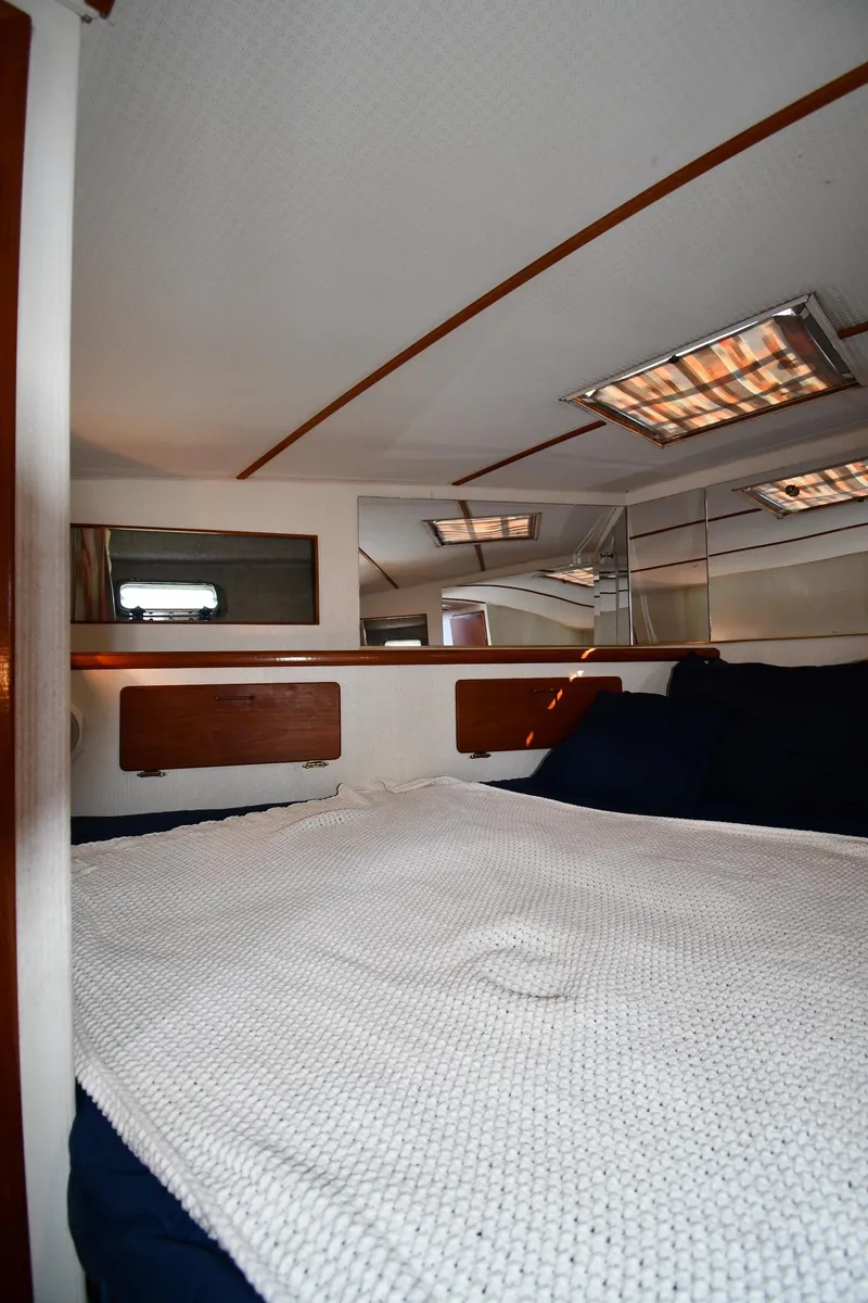 Slide: The Image of 1988 Tollycraft 34 Sundeck cabin interior with bed and wooden accents. - 31