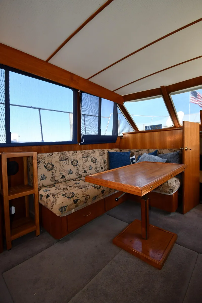Slide: The Image of 1988 Tollycraft 34 Sundeck interior with dining area and floral-patterned seating. - 39