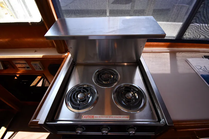 Slide: The Image of 1988 Tollycraft 34 Sundeck kitchen stove with three burners. - 45