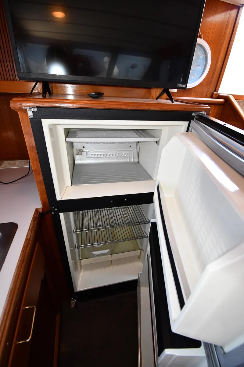 Slide: The Image of 1988 Tollycraft 34 Sundeck yacht kitchen with open refrigerator and TV - 47