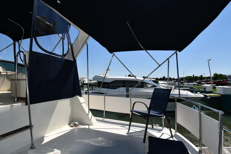 Slide: The Image of 1988 Tollycraft 34 Sundeck yacht with shaded seating area at marina. - 7