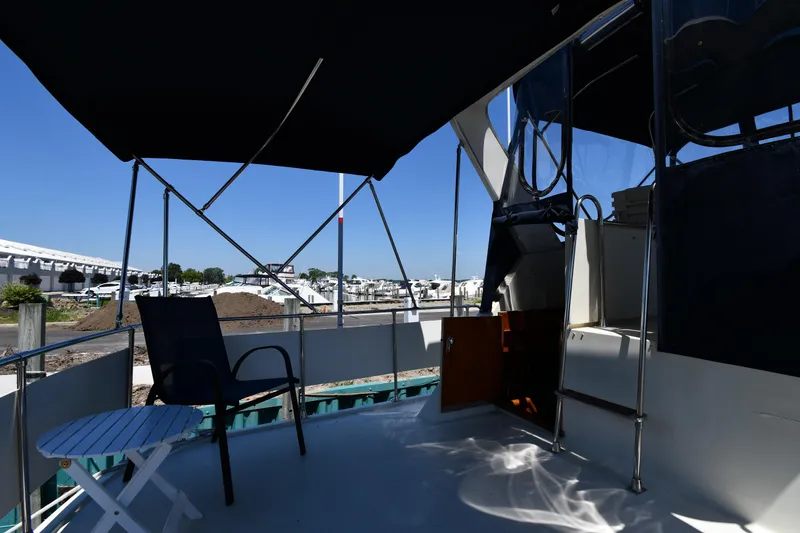 Slide: The Image of 1988 Tollycraft 34 Sundeck yacht with shaded deck area and outdoor seating. - 9