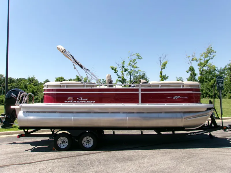 The Image of 2024 Sun Tracker Party Barge 22 RF XP3 pontoon boat on trailer, parked outdoors. - 0