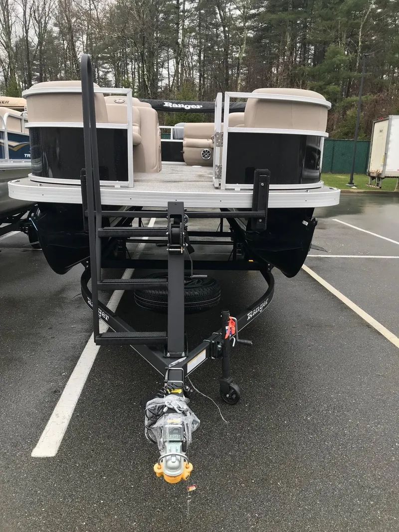 Slide: The Image of 2024 Ranger Reata 200F pontoon boat on trailer in parking lot. - 2